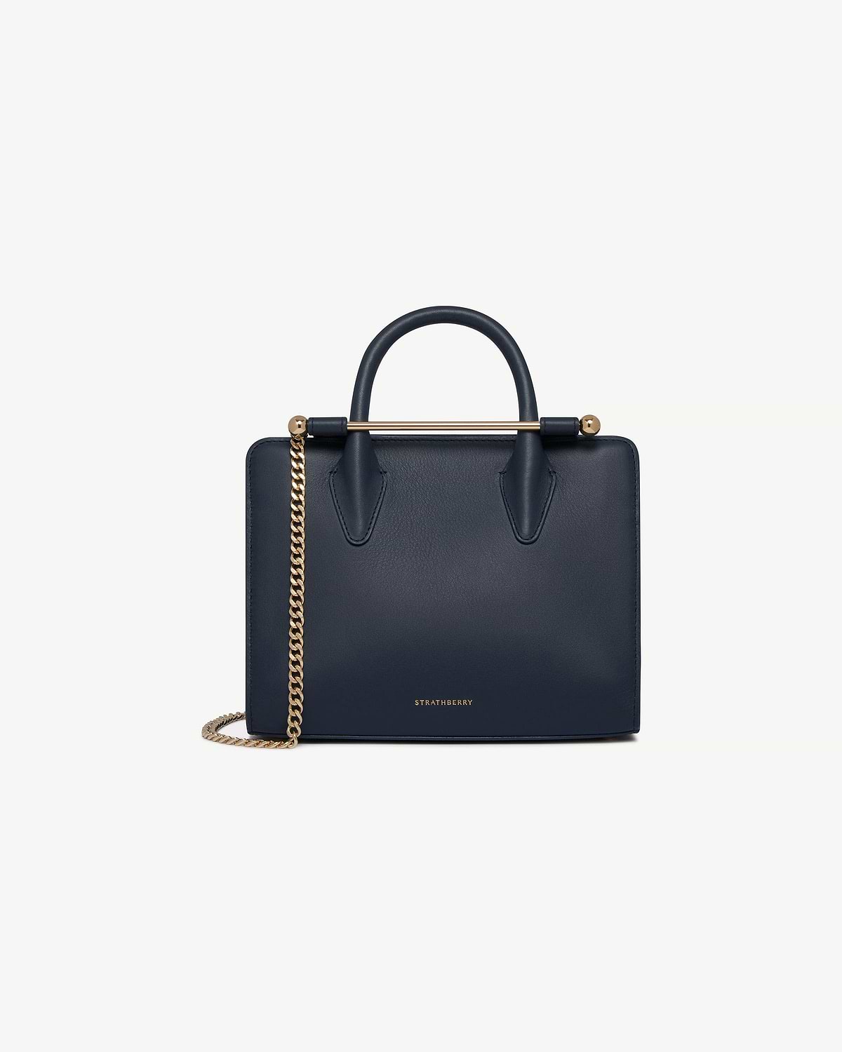 Strathberry marine blue mini tote with top handles and gold chain strap.