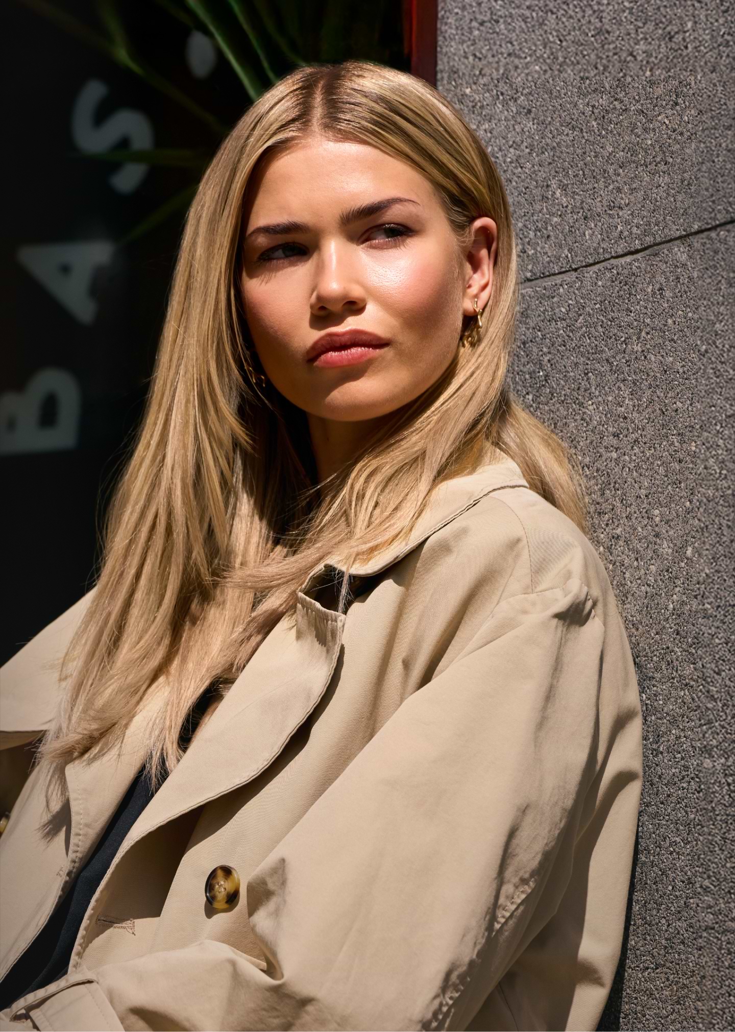 Women with long blond hair and a coat in a cafe