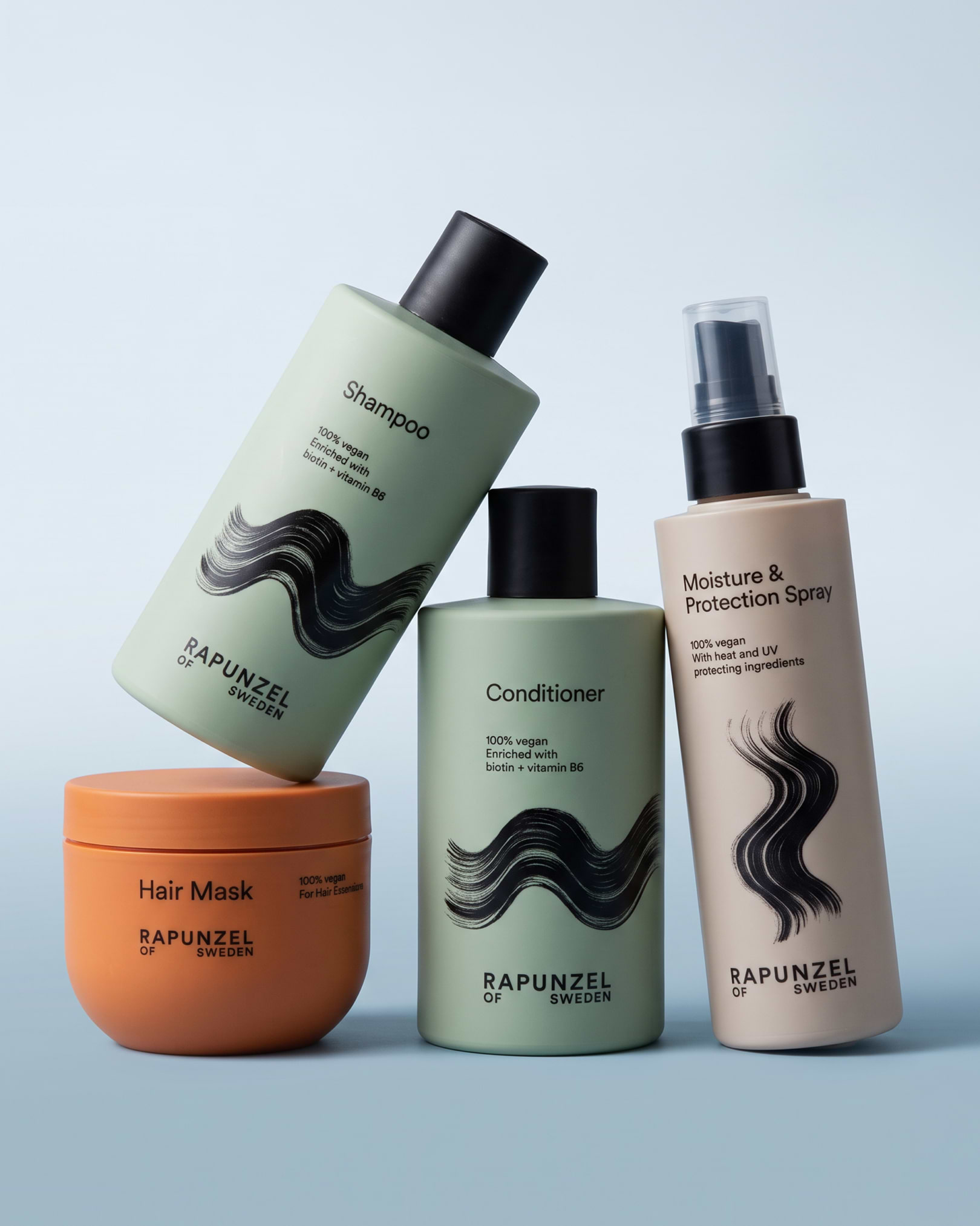 Four bottles of Rapunzel of Sweden haircare products, including shampoo, conditioner, hair mask, and moisture & protection spray, on a light blue background.