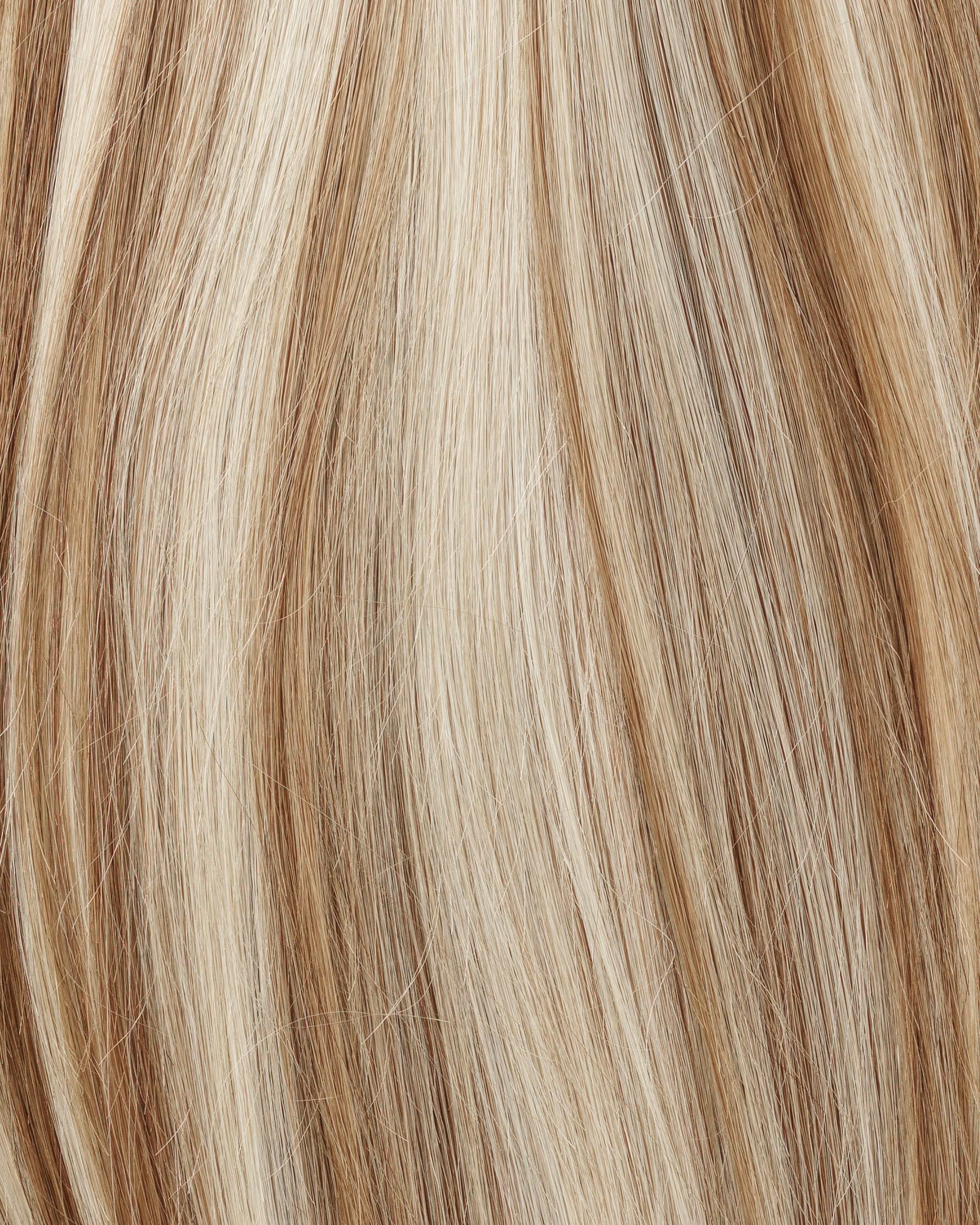 Close-up of wavy hair with a blend of light blonde and brown highlights, creating a textured and natural look.