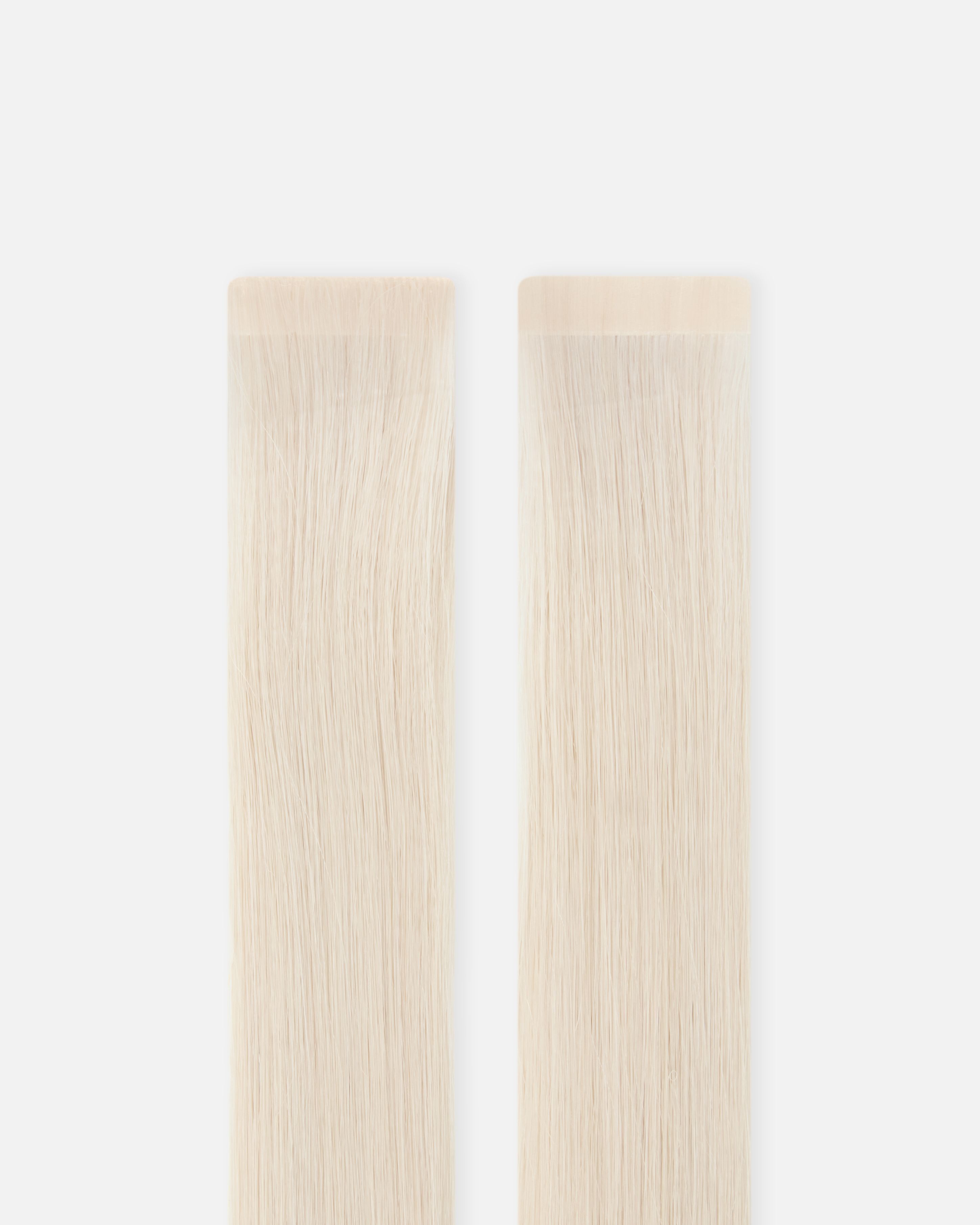 Two long, straight strips of light blond hair extensions against a white background.
