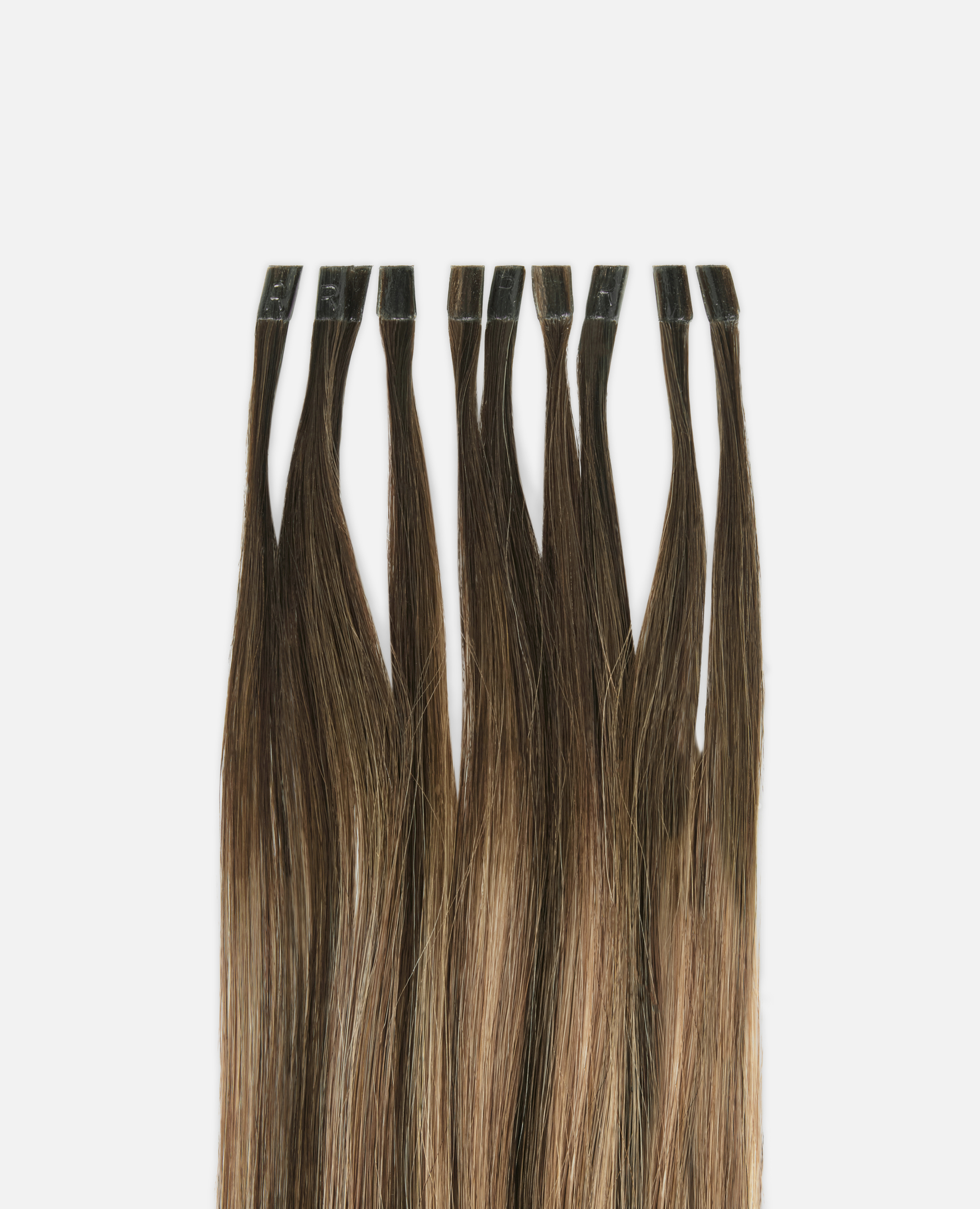 Brown hair extensions laid out side by side against a white background, showing varying shades and smooth texture.
