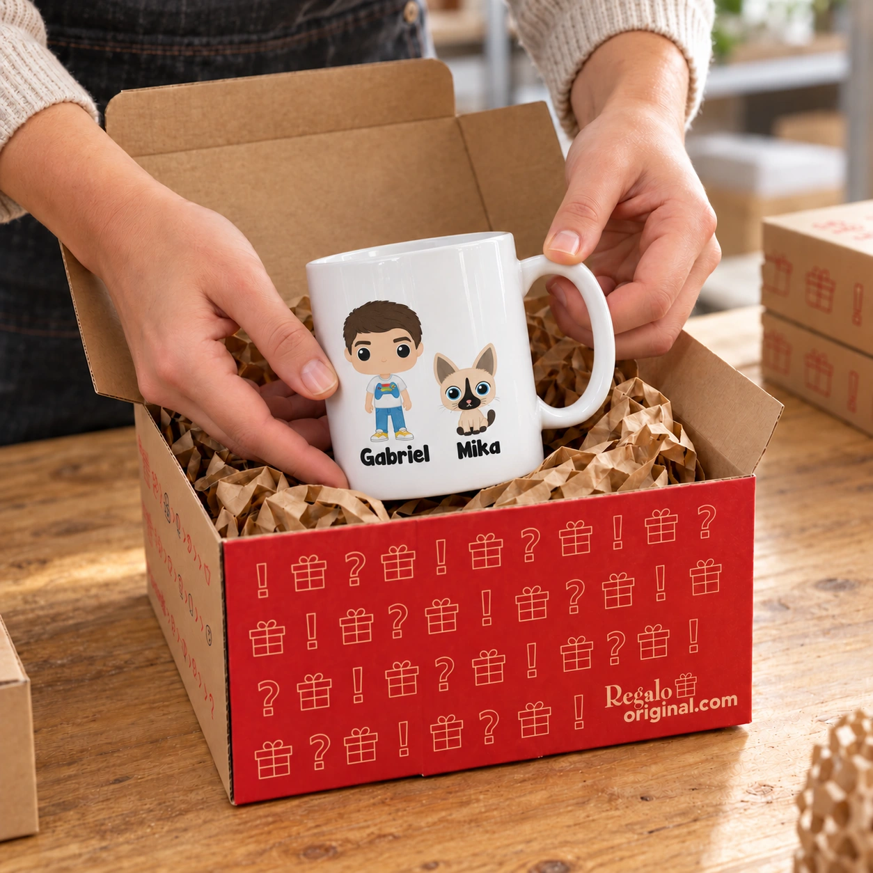 Eine Tasse mit dem Funko-Design von Gabriel und Mika wird liebevoll in eine Regalo-Original-Box gelegt