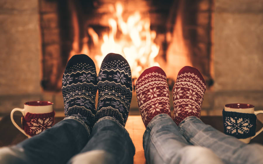 Couple in winter next to a fireplace