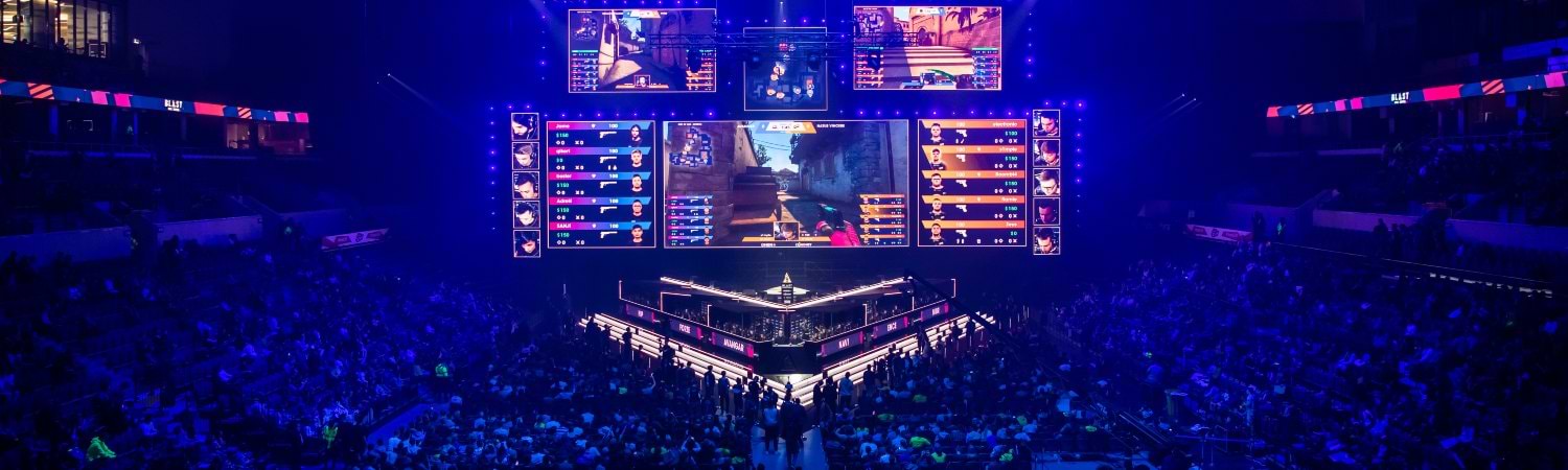 Arena de Esports con escenario iluminado y espectadores durante torneo competitivo