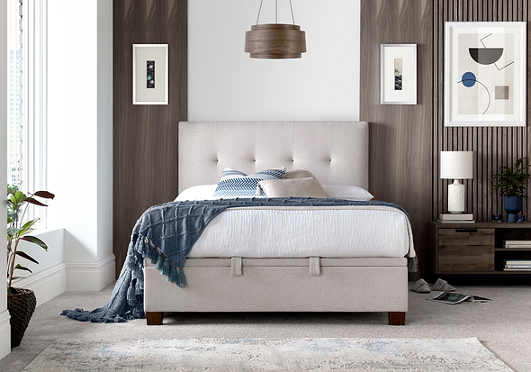 Luxurious pale cream fabric ottoman bed frame with modern dark wooden feet.