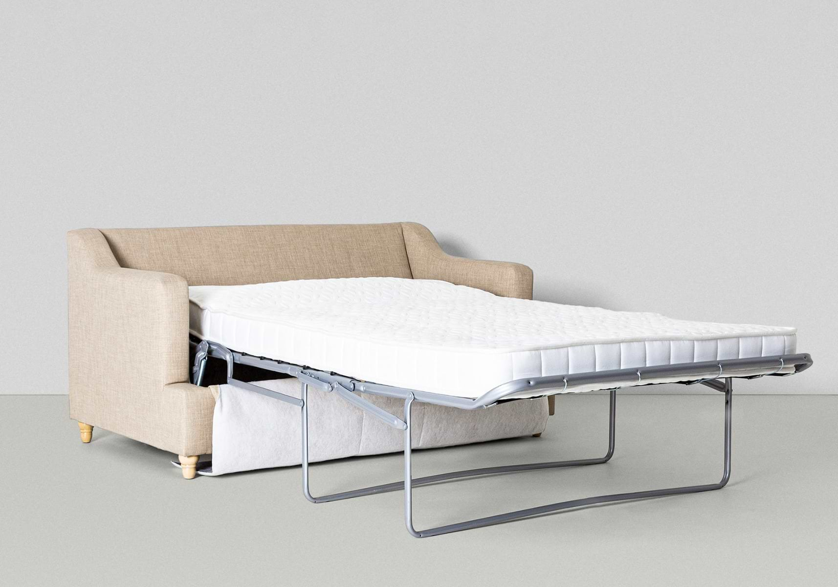 beige sofa bed that is in bed form