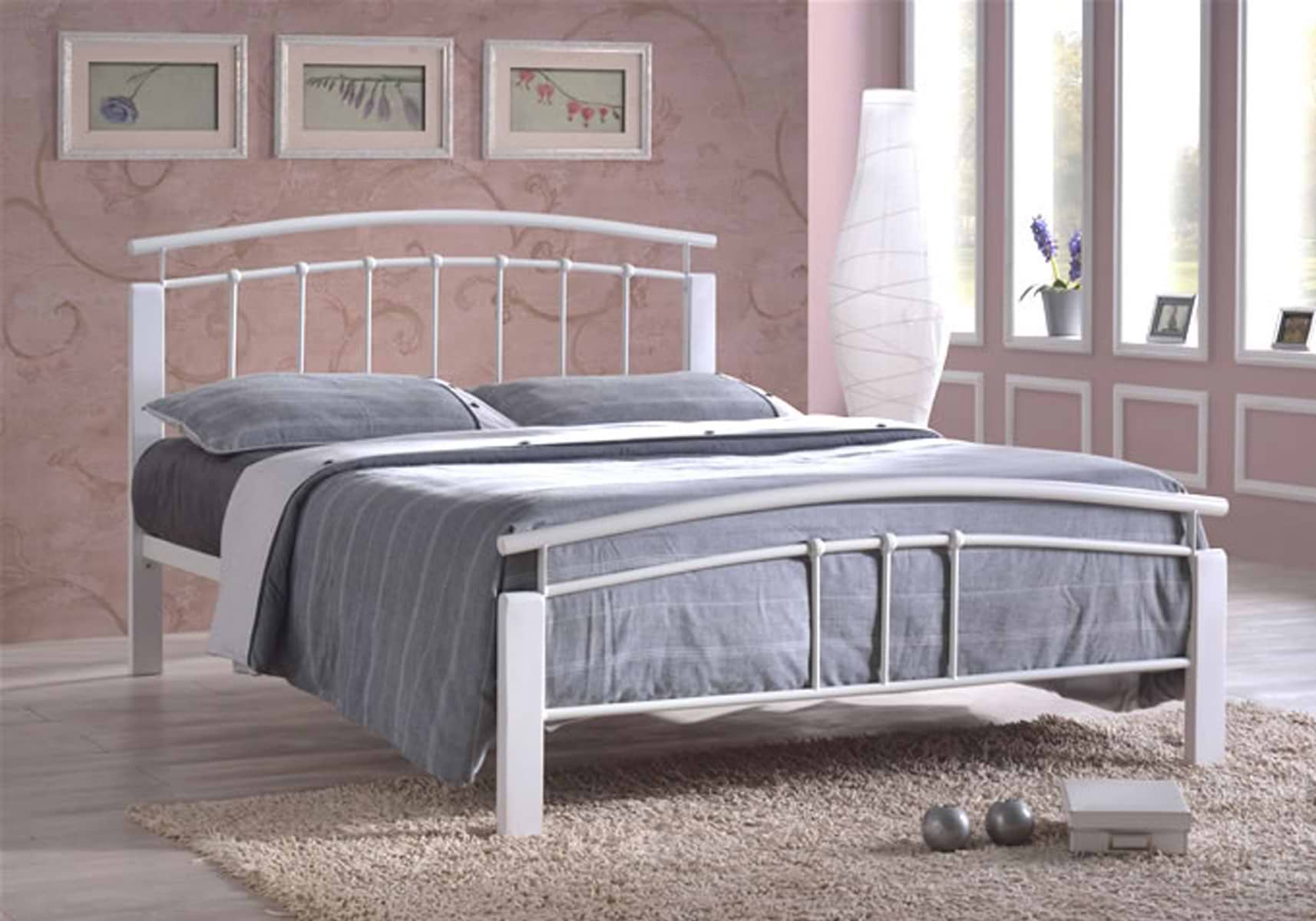 White metal double bed with grey bedsheets