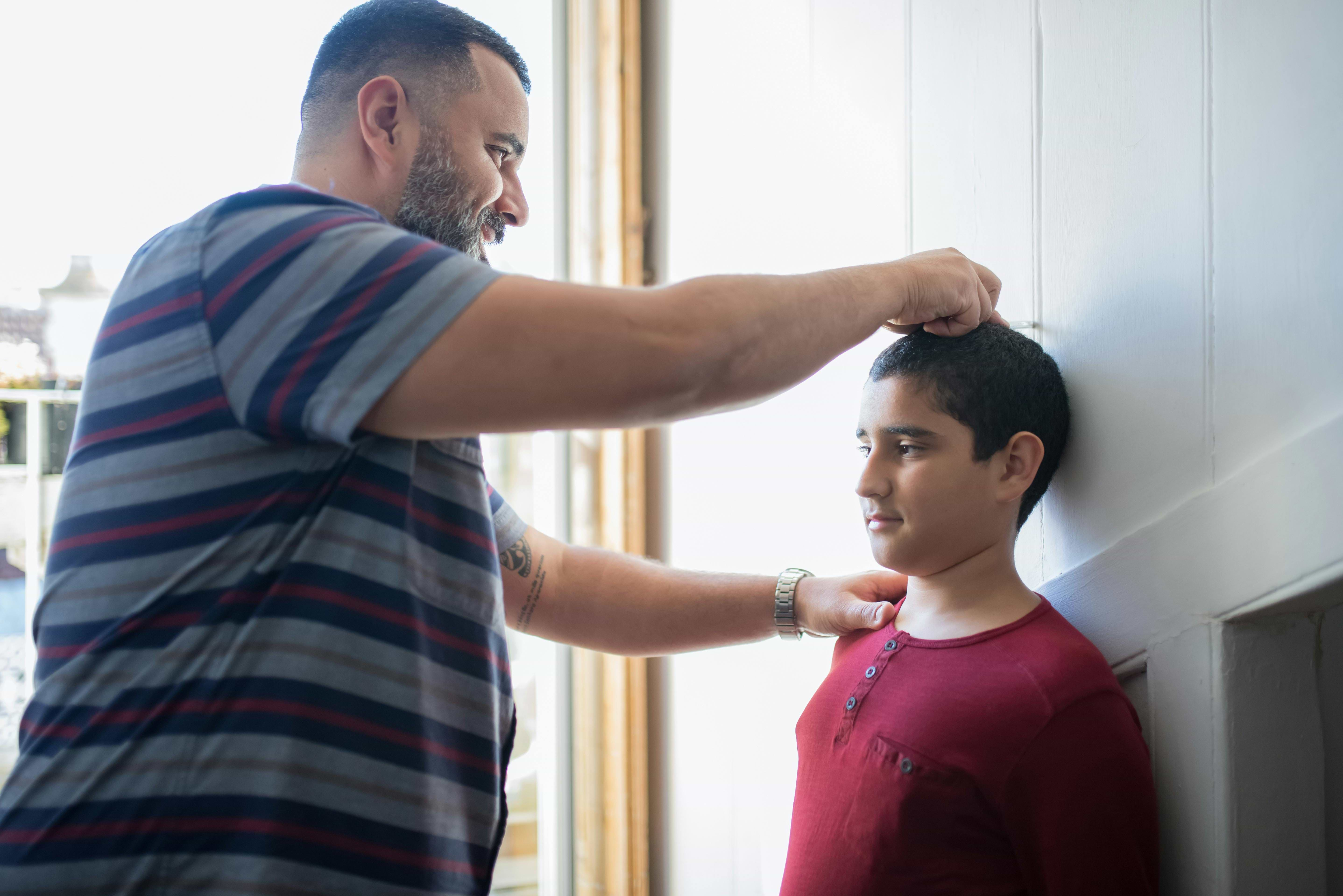 Father measuring height of child