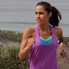 woman wearing sweatproof earbuds while running