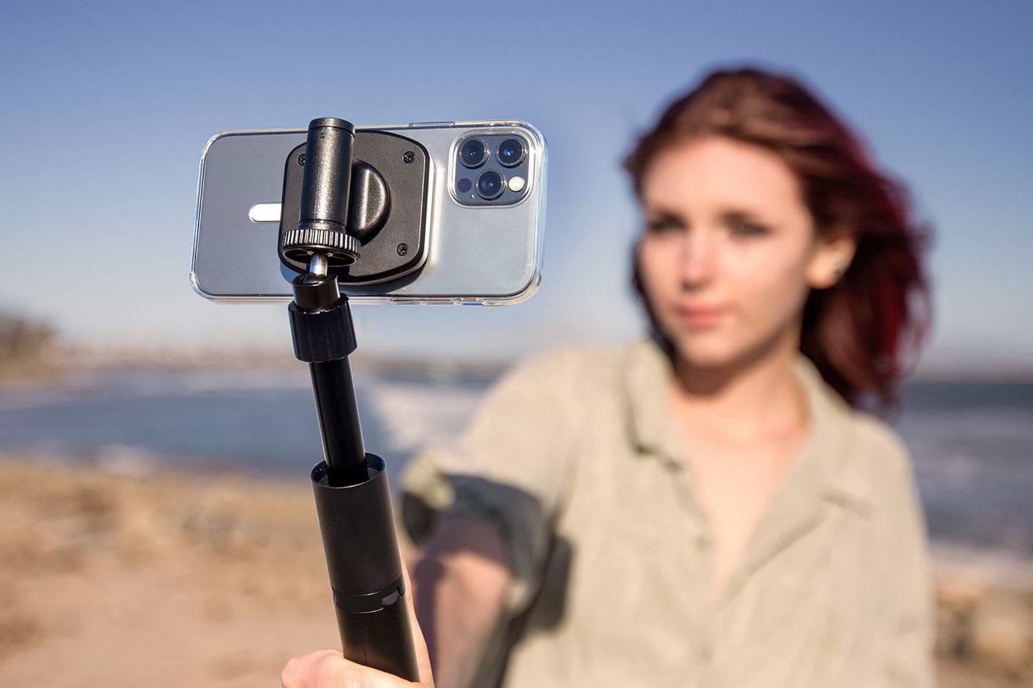 woman holding iphone for taking selfie using Scosche MagSafe tripod