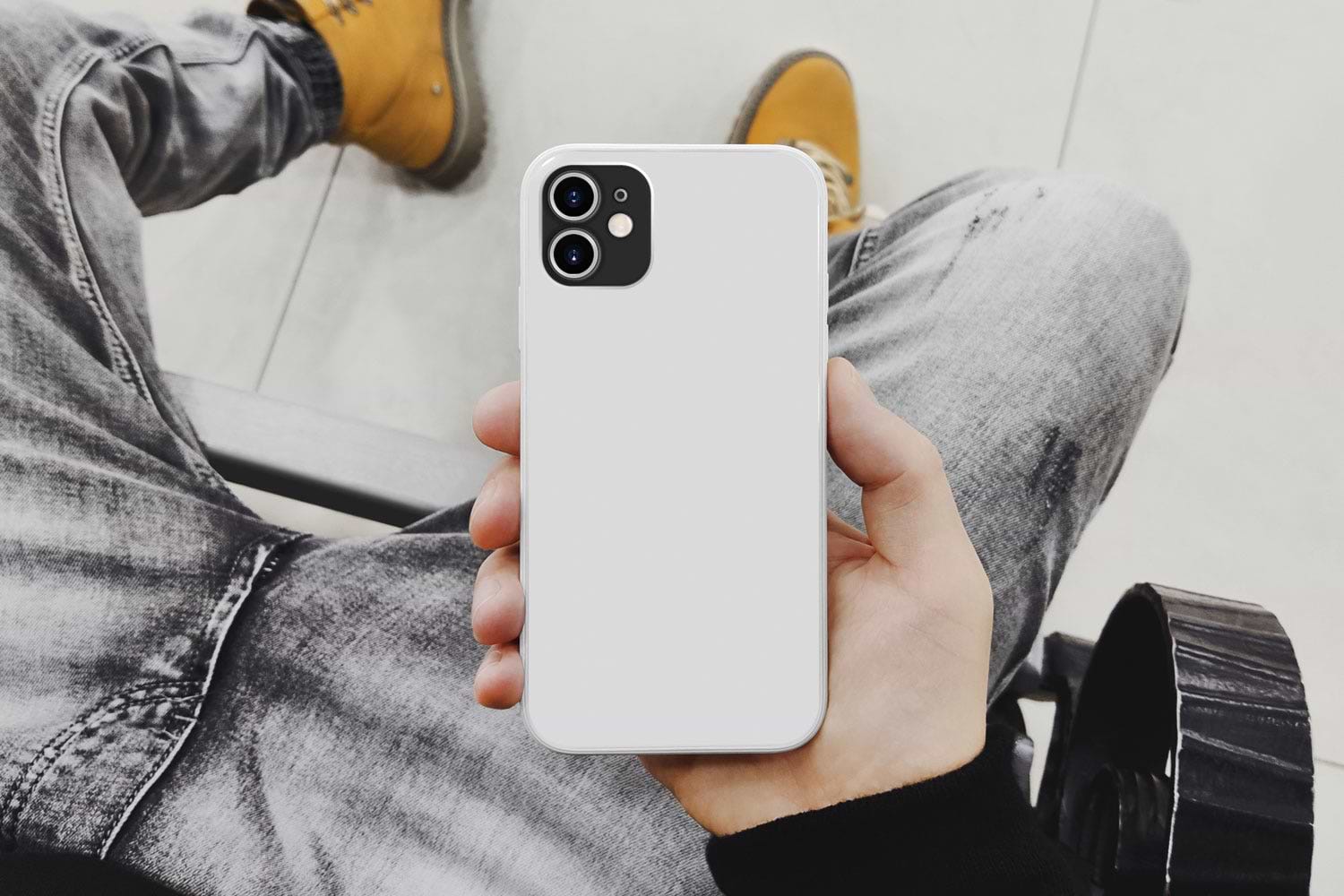 man holding iphone showing back of white case
