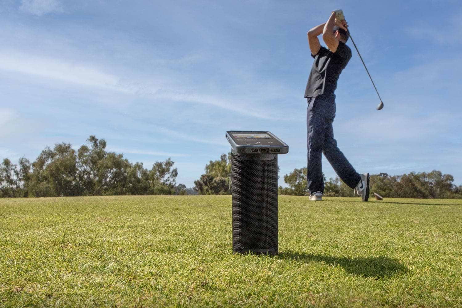 man golfing while listening to music via Scosche MagSage wireless speaker
