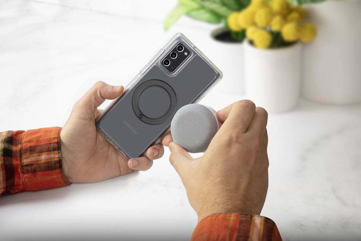 man holding Samsung phone attaching MagSafe wireless bluetooth speaker using Scosche MagicRing magnetic adapter