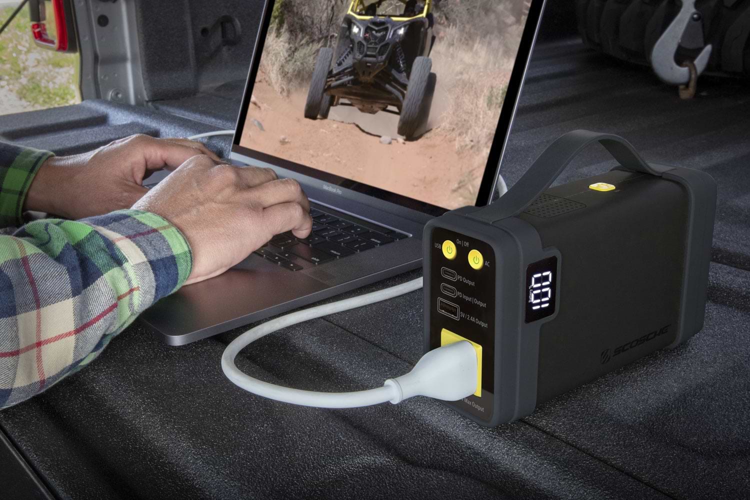 man using laptop while charging via portable power station
