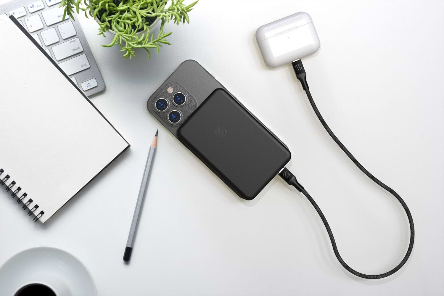 iphone charging on desk via Scosche MagSafe portable power bank with Airpods charging via cable