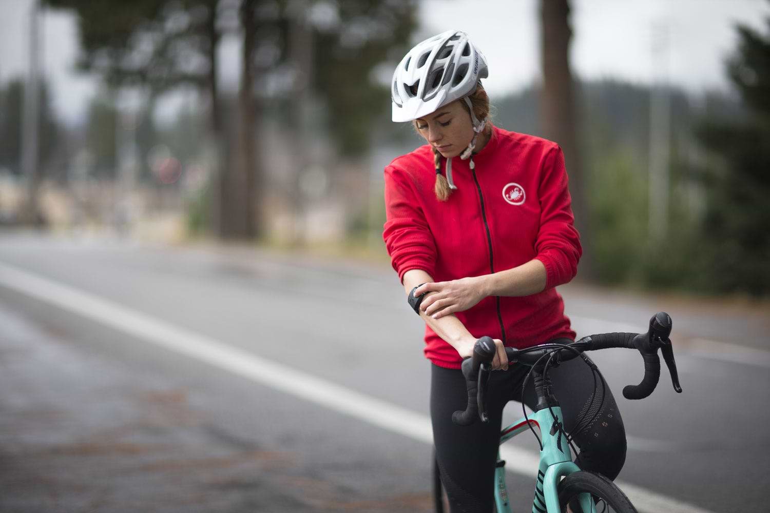 woman on bike checking armband heart rate monitor