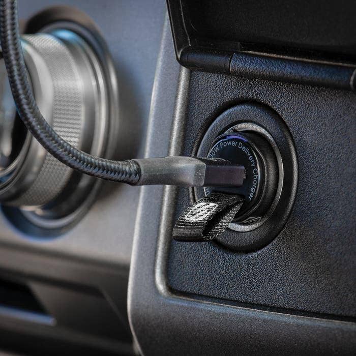 car lighter attachment close up of scosche charging cable connected to fast charger in car 12v socket