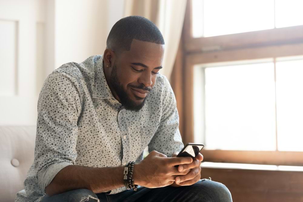 happy man using phone happy man using phone sitting on sofa