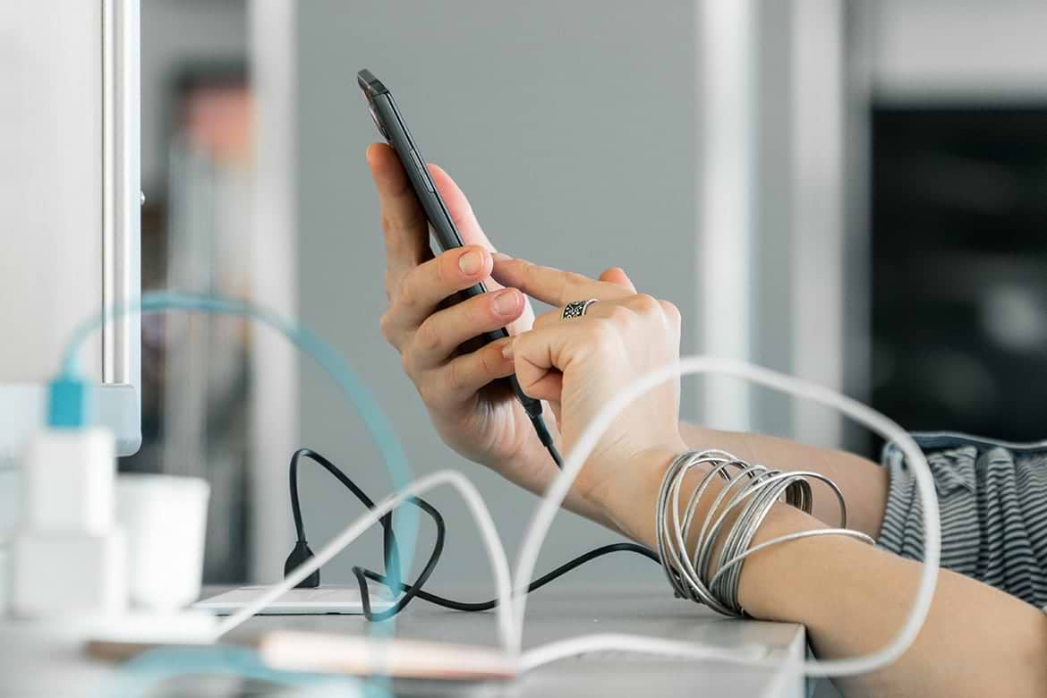 using smartphone woman holding smartphone with various charging cables