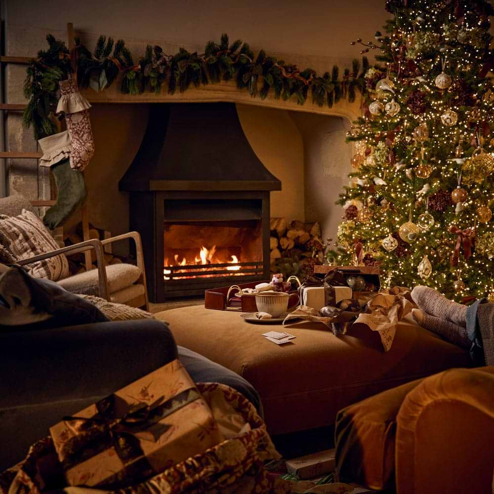 A cosy firesides scheme with a Christmas tree